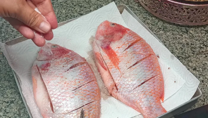 Rub salt all over the fish, then rinse with clean water.