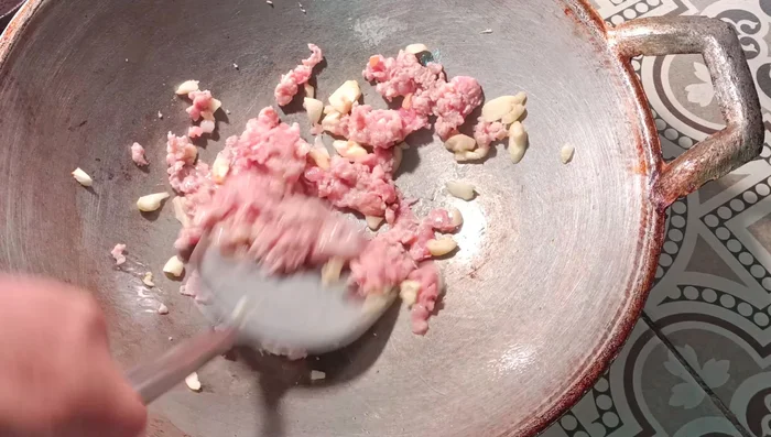 Add the minced pork and stir-fry until cooked.