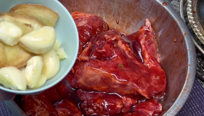 Add garlic and ginger to the marinated pork.