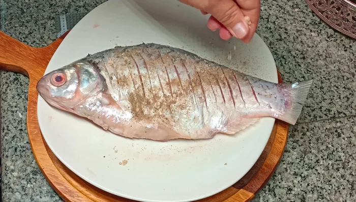 Remove the fried carp and finger root from the pan and drain on a plate lined with paper towels.