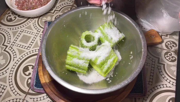 Rub the bitter melon sections generously with coarse salt, inside and out, for several minutes. This helps reduce bitterness.