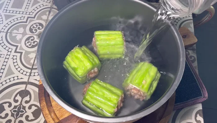 Place the stuffed bitter melon in the electric pressure cooker. Add water, stock cube (1-2), dried shrimp, and sliced shiitake mushrooms.