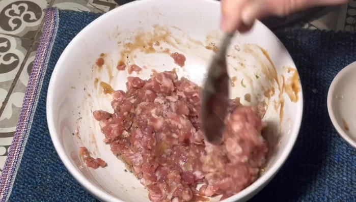 Add glass noodles to the pork mixture and stir.