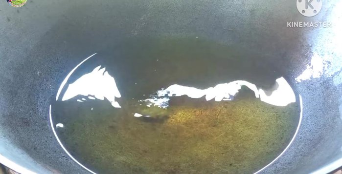 Heat palm oil in a frying pan until hot enough to make a piece of rice puff up.