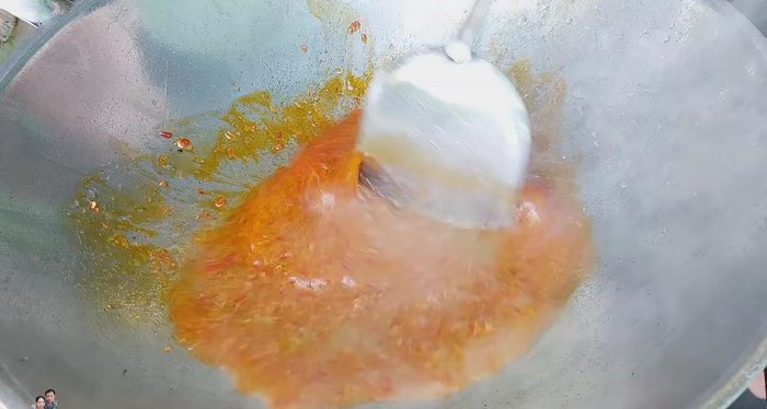 Add water and continue to stir-fry the curry paste until fragrant.