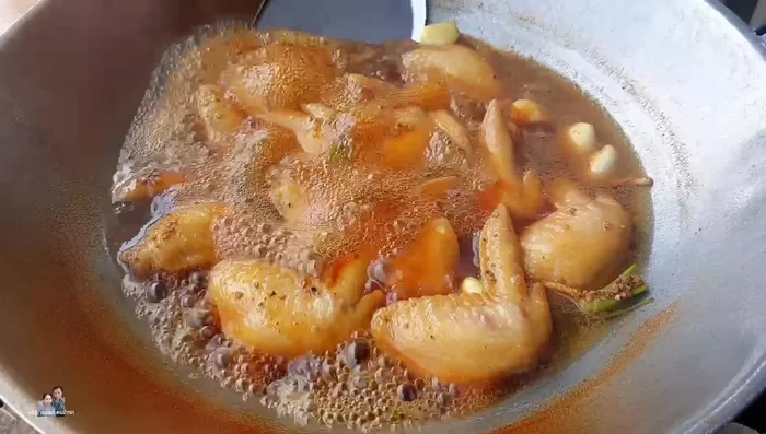 Once the chicken wings are tender (after about 20 minutes), remove from the pot and arrange on a plate. Pour the soy sauce cooking liquid generously over the chicken wings. Garnish with coriander.
