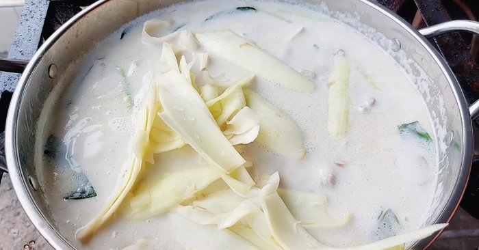 Add banana blossom: Once the chicken is cooked, add the prepared banana blossom. Press down gently to ensure even cooking and prevent discoloration. [296.4]