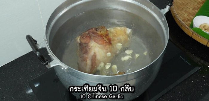 Add the fried pork leg, crushed Chinese garlic, crushed coriander root, pork soup cube, black pepper, and chopped carrots to the boiling water.