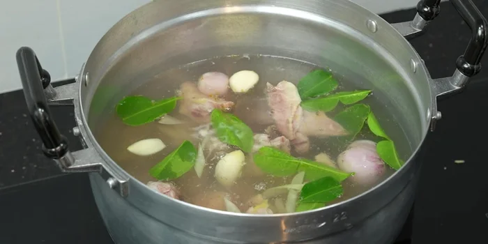 Once the broth boils again, add the cleaned and cut chicken internal organs.