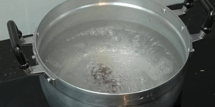 Add tamarind, shallots, crushed garlic, galangal, lemongrass, and kaffir lime leaves to the boiling water. Let it simmer for a while to release the aromas.