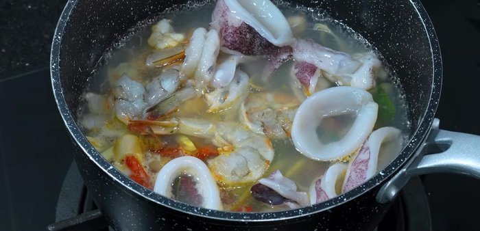 Increase heat and cook until shrimp and squid are done.
