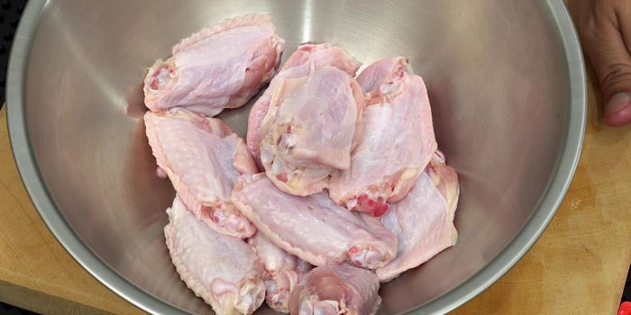 In a stainless steel basin, marinate the chicken wings with fish sauce, salt, and optionally soy sauce. Marinate for at least 30 minutes.