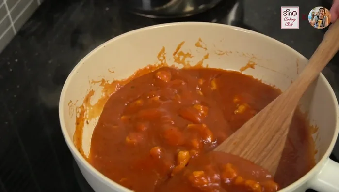 Once the sauce is heated and boiling, drain the cooked spaghetti and add it to the pan.