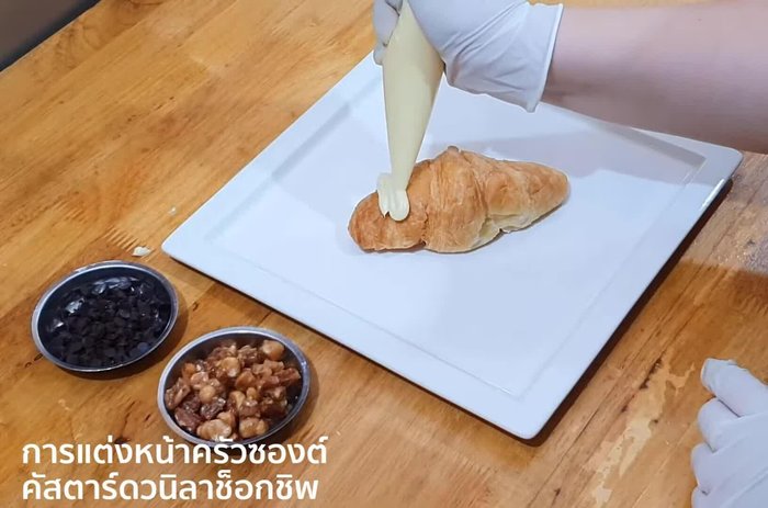 Slowly squeeze custard onto the bag.