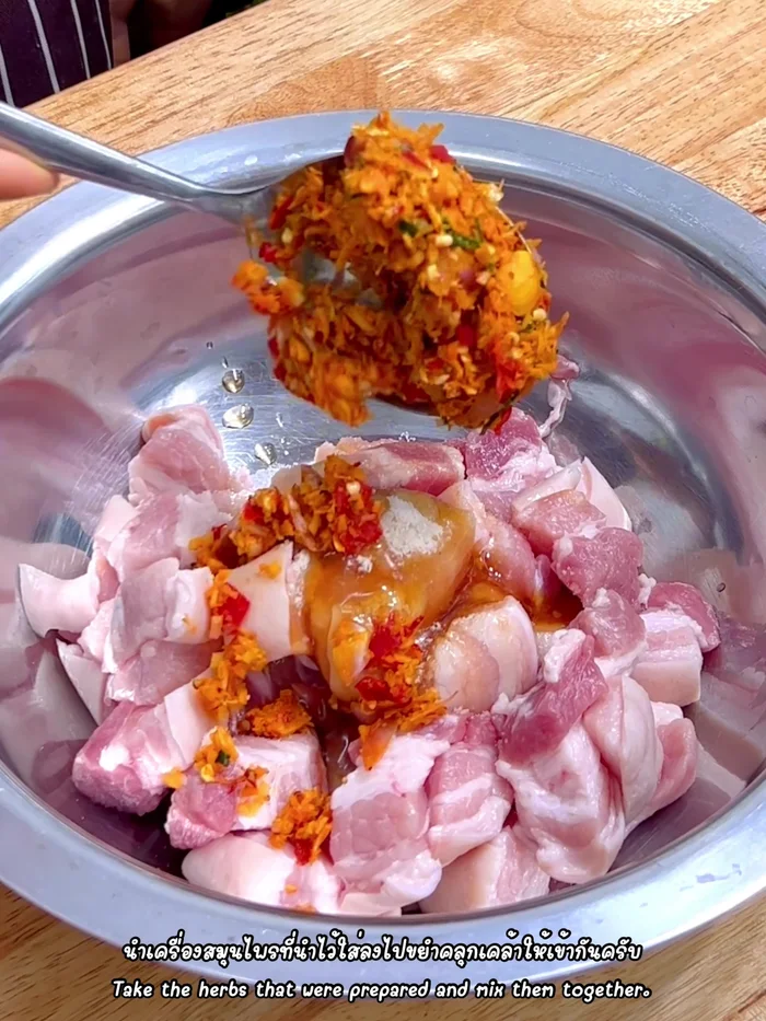 Add the pounded herbs to the seasoned pork. Mix well, ensuring the herbs are incorporated into the pork belly. Add extra chili peppers for color if desired.