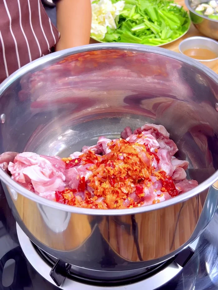 Heat the pot on low heat. Fry the pork with bones and the curry paste until fragrant. (185.319)