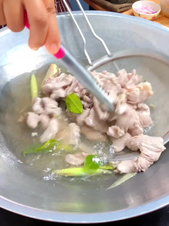Drain the cooked pork and let it cool.