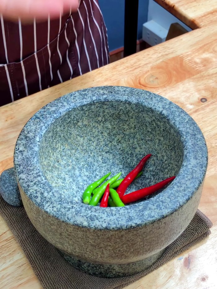 Make the sauce: Pound the chili peppers, garlic, and coriander roots together until fine. Add coconut sugar, lime juice, and fish sauce. Knead until the sugar melts into the sauce.