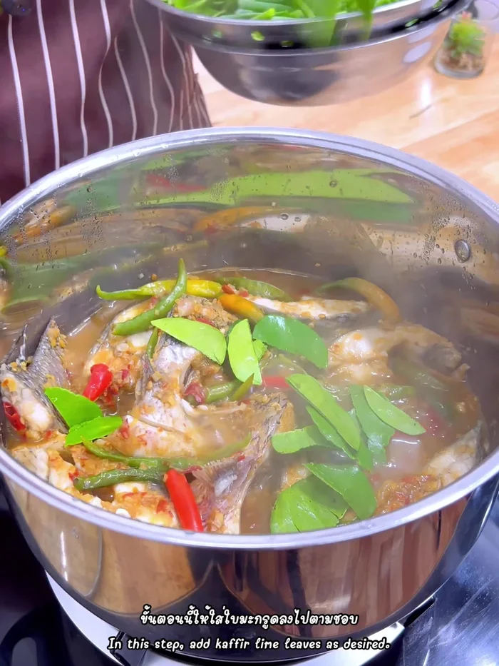 Add torn kaffir lime leaves, chopped spring onions, and coriander/basil.