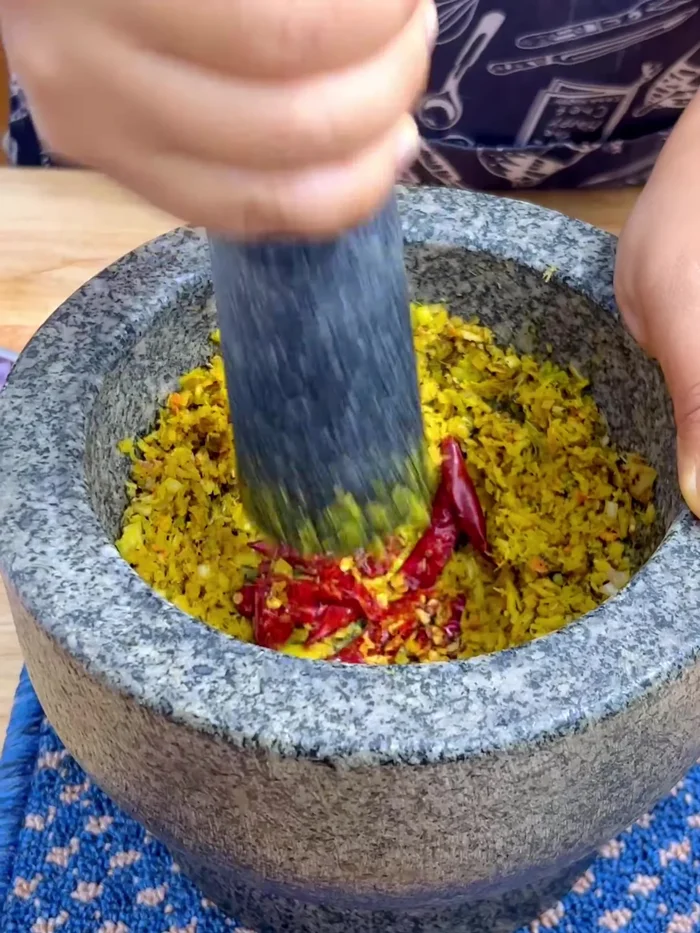 Add dried chili to the pounded herbs. Adjust the spiciness to your liking.