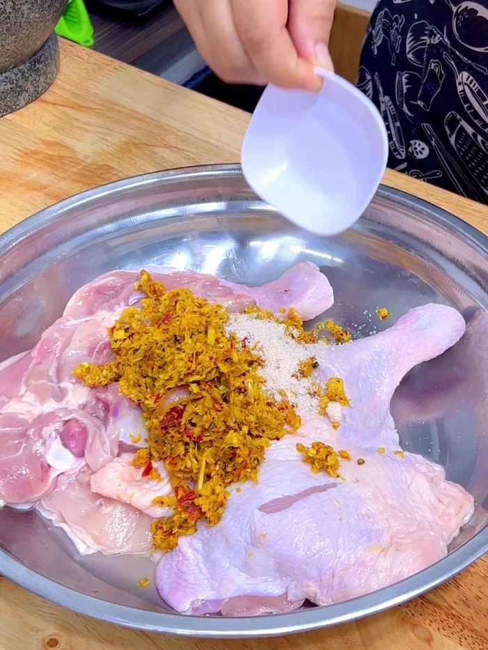 Marinate the chicken: Add the pounded herb mixture, chicken seasoning powder, sugar, white soy sauce, fish sauce, and oyster sauce to the chicken. Mix well.