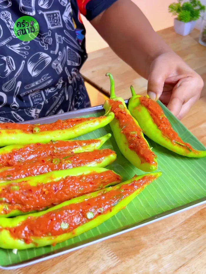 Heat oil in a frying pan over medium heat. Carefully place the stuffed peppers in the hot oil, and let them set before flipping.