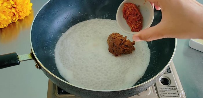 Bring coconut milk to a boil, then add 3-4 tablespoons of yellow curry paste and 1/2 tablespoon of duck curry paste for color. Stir-fry until thickened.