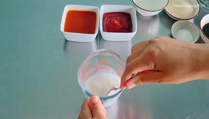In a pot, combine the blended bean curd mixture, salt (1 tsp), sugar (3 tbsp), vinegar (2 tbsp), oyster sauce (50g), tomato sauce (100g), and chili sauce (100g).