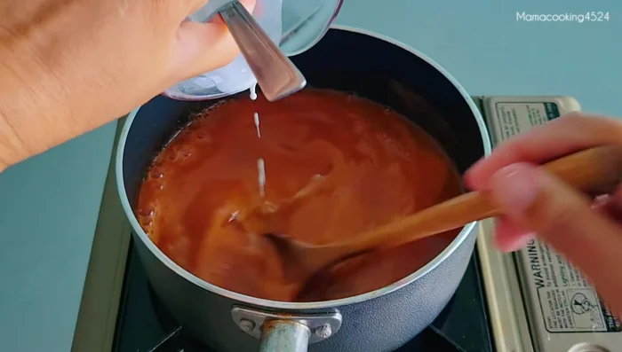 Cook over medium heat, stirring continuously until the sauce boils. Add red food coloring (2 drops, optional).