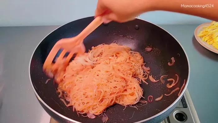 Add the soaked rice vermicelli, stir-fry until heated through. Add the egg strips and tofu.