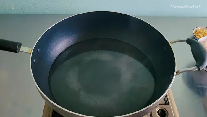 Heat 1200 ml of water in a pot. Add grated lemongrass and lime leaves.