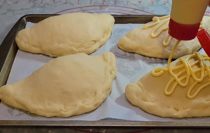 Brush with egg wash, sprinkle with mozzarella cheese. [508.039]