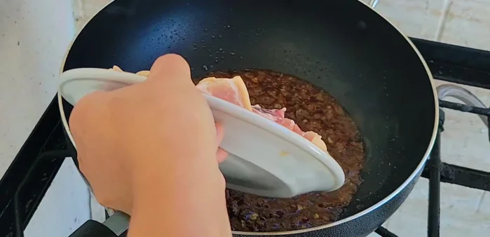 Add 500 grams of pork belly (cut into large pieces) and stir-fry until firm.